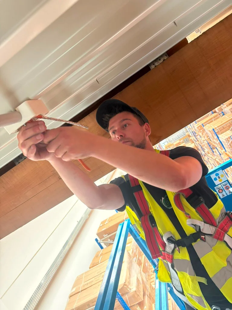 Connect@home Techniker installiert Enterprise-WLAN auf Scherenbühne in einem Hochregallager